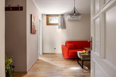 a living room with a red couch and a wooden floor at Baglio dei Conti d'Orléans in Palermo