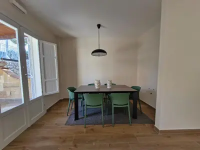 a dining room with a black table and green chairs at Finestra sul Golfo in Mondello
