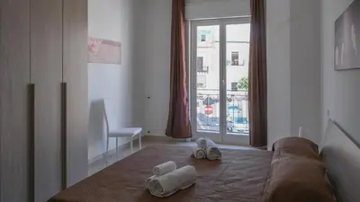 a bedroom with towels on a bed with a window at Terrasini Downtown Little Square in Terrasini