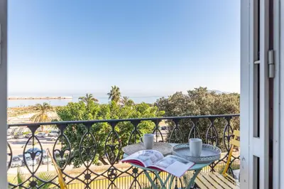 a balcony with a table with two cups and a book at La Casa al Foro Vista Mare by Wonderful Italy in Palermo