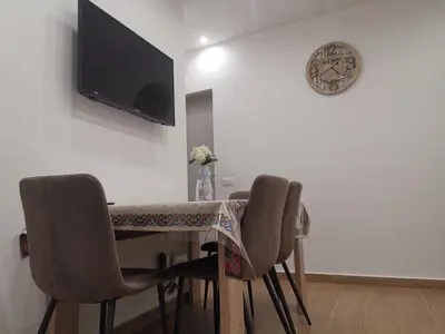 a dining room table with chairs and a clock on the wall at Primo Piano in Palermo