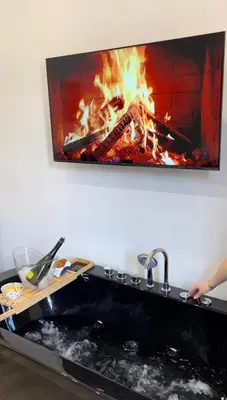 a fire in a fireplace with a tv on the wall at Sweet dreams in Palermo