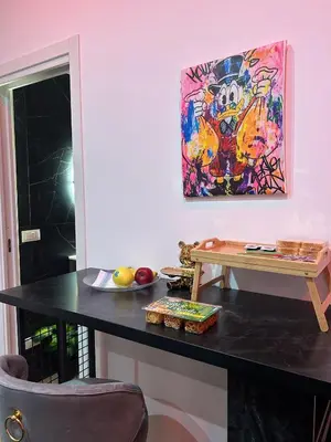 a table in a room with a painting on the wall at Sweet dreams in Palermo