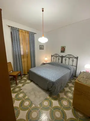 a bedroom with a bed with a blue comforter at Villa Pino in Carini