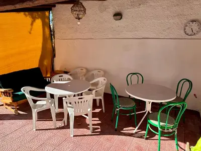a room with tables and chairs and a clock on the wall at Villa Pino in Carini