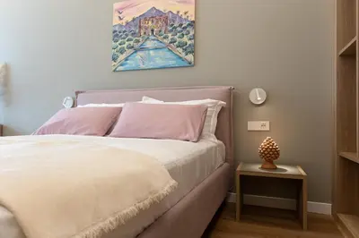 a bedroom with a bed with a painting on the wall at Quattro Canti Deluxe in Palermo