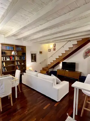 a living room with white furniture and a staircase at Casa Vacanze Sfera 6 in Palermo