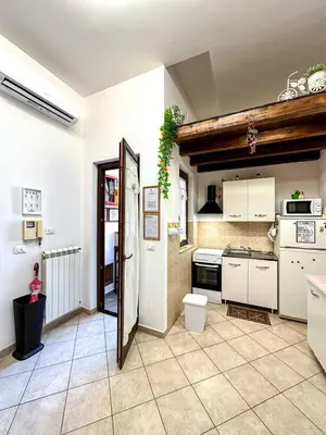 a kitchen with white cabinets and a tile floor at Balat City in Palermo