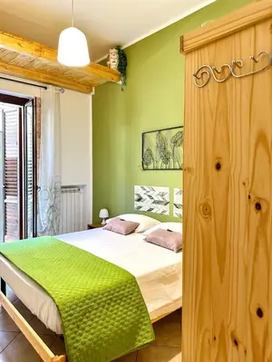 a bedroom with a large bed with green walls at Balat City in Palermo