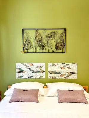 a bedroom with a green wall with a white bed at Balat City in Palermo