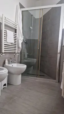 a bathroom with a shower and a toilet and a sink at Brunetto House in Palermo