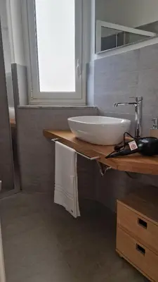 a bathroom with a white sink and a mirror at Brunetto House in Palermo