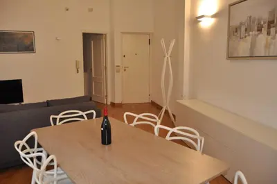 a dining room with a table and white chairs at Brunetto House in Palermo