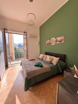 a bedroom with a bed and a large window at Suli D'amuri in Palermo