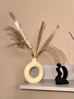 a yellow vase sitting on a shelf with feathers at Suli D'amuri in Palermo