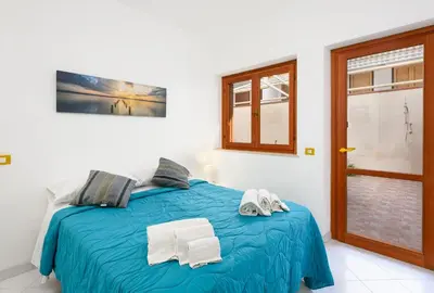 a bedroom with a blue bed with towels on it at Trilocale Mulino Superior in San Vito lo Capo