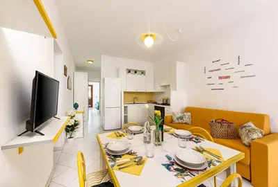 a kitchen and a living room with a table and a television at Trilocale Mulino Superior in San Vito lo Capo