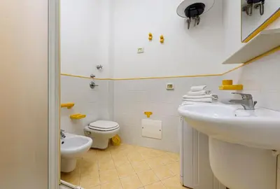 a white bathroom with a sink and a toilet at Trilocale Mulino Superior in San Vito lo Capo