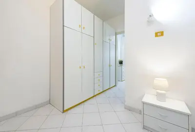 a white room with white cabinets and a lamp at Trilocale Mulino Superior in San Vito lo Capo
