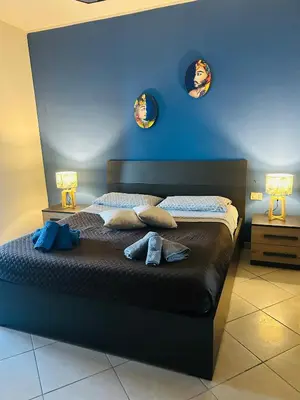 a bedroom with a bed with two lamps on it at Casa Aura in Palermo