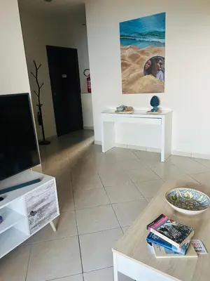 a living room with a table and a painting on the wall at Casa Aura in Palermo