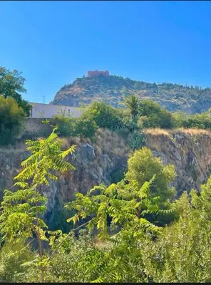 a hill with trees and a bridge in the background at Casa Aura in Palermo