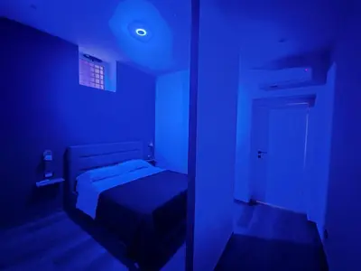a blue room with a bed and a mirror at Trinacria Guest house in Palermo