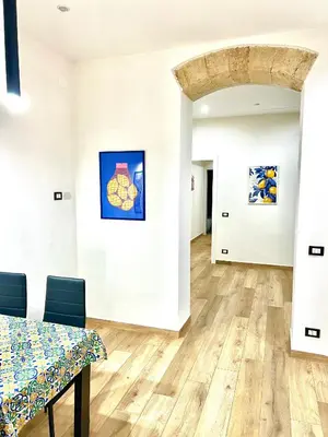 a room with a table and paintings on the walls at Trinacria Guest house in Palermo