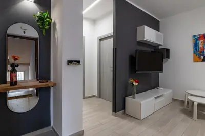 a living room with a mirror and a tv at GuestHost - Sicilian Dream - Modern Central Apartment in Palermo