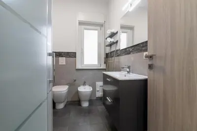 a bathroom with two toilets and a sink and a mirror at GuestHost - Sicilian Dream - Modern Central Apartment in Palermo