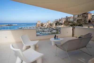 a balcony with chairs and a table and a view at Casa del Porto in Castellammare del Golfo