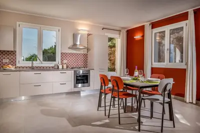 a kitchen with a table and chairs in a room at Villa Orizzonte in Scopello