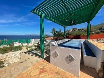 a green roof over a patio with a view of the ocean at Villa Venere al Sauce - esclusiva villa sul mare in San Vito lo Capo