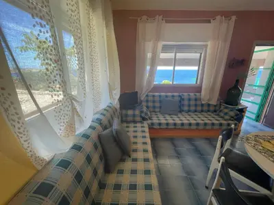 a living room with a couch and a window at Villa Venere al Sauce - esclusiva villa sul mare in San Vito lo Capo