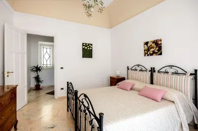 a bedroom with a bed with pink pillows on it at TorreKalsa Apartment by Wonderful Italy in Palermo
