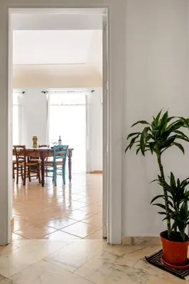 a dining room with a table and a potted plant at TorreKalsa Apartment by Wonderful Italy in Palermo