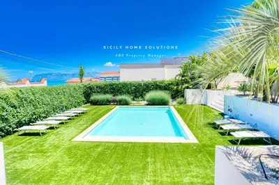 a swimming pool in the middle of a lawn with lounge chairs at Oasi Elegante Piscina di Lusso - vista panoramica By Sicily Home Solutions in Alcamo