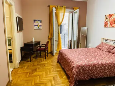 a bedroom with a bed and a desk and a table at la casa di Tati Palermo centro in Palermo