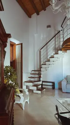 a living room with a staircase and a couch at I Tamarindi in Palermo