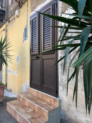 a wooden door on the side of a building with stairs at Casetta Bedda in Palermo