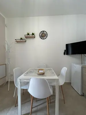 a white dining room with a white table and chairs at Casetta Bedda in Palermo