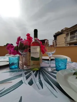 a bottle of wine sitting on a table with glasses at Casa Maria Elena in Santa Flavia