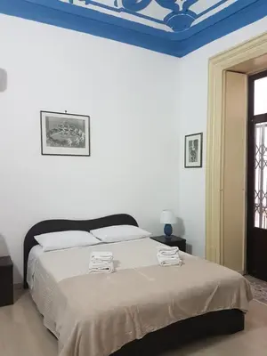 a bedroom with a bed with a blue ceiling at Vucciria room in Palermo