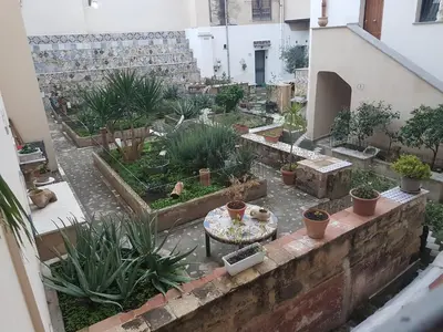 an outdoor garden with potted plants and a table at Vucciria room in Palermo