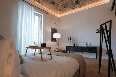 a bedroom with a bed with a table and a window at Casamusa suite in Palermo