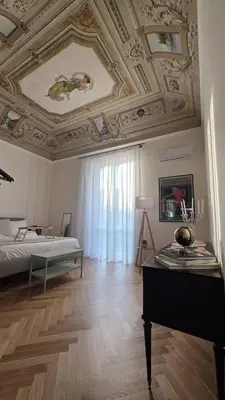 a room with a ceiling with a bed and a table at Casamusa suite in Palermo