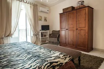 a bedroom with a bed and a large wooden cabinet at Trip Rooms 2 in Palermo