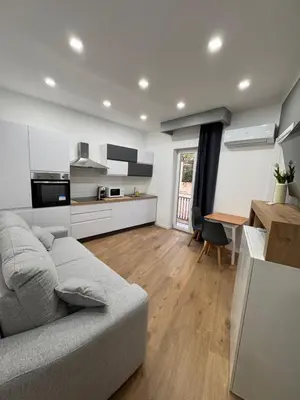 a living room with a couch and a kitchen at Domus ad Max- La casa nel cuore di Palermo in Palermo