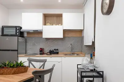 a kitchen with white cabinets and a table with chairs at 105 Apartments in Palermo