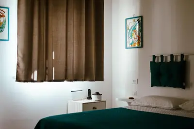 a bedroom with a green bed and a window at Villa Torre Ulisse Locazione Turistica Affitti Brevi in Carini